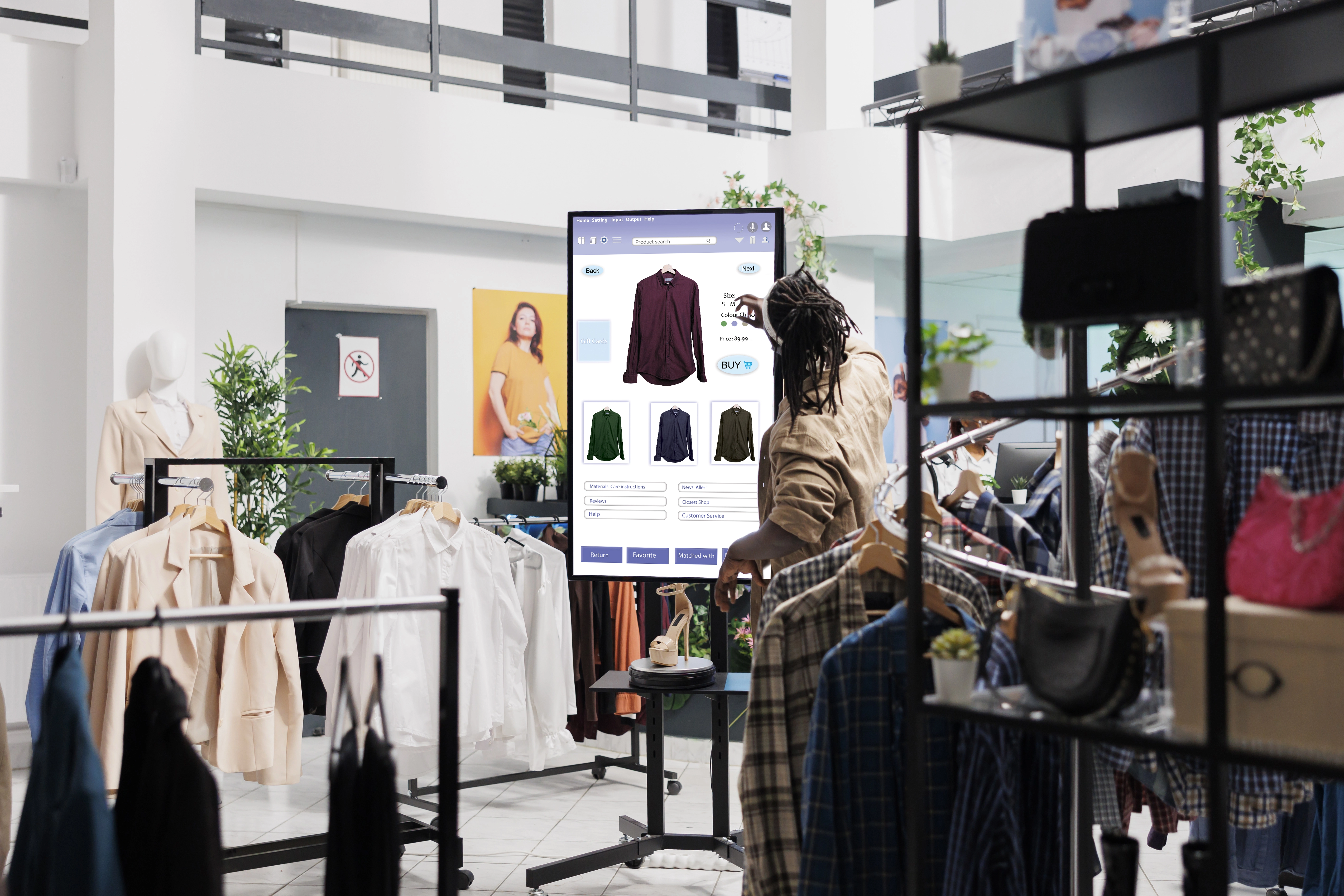 a person standing in a store and looking at clothes on a touchscreen
